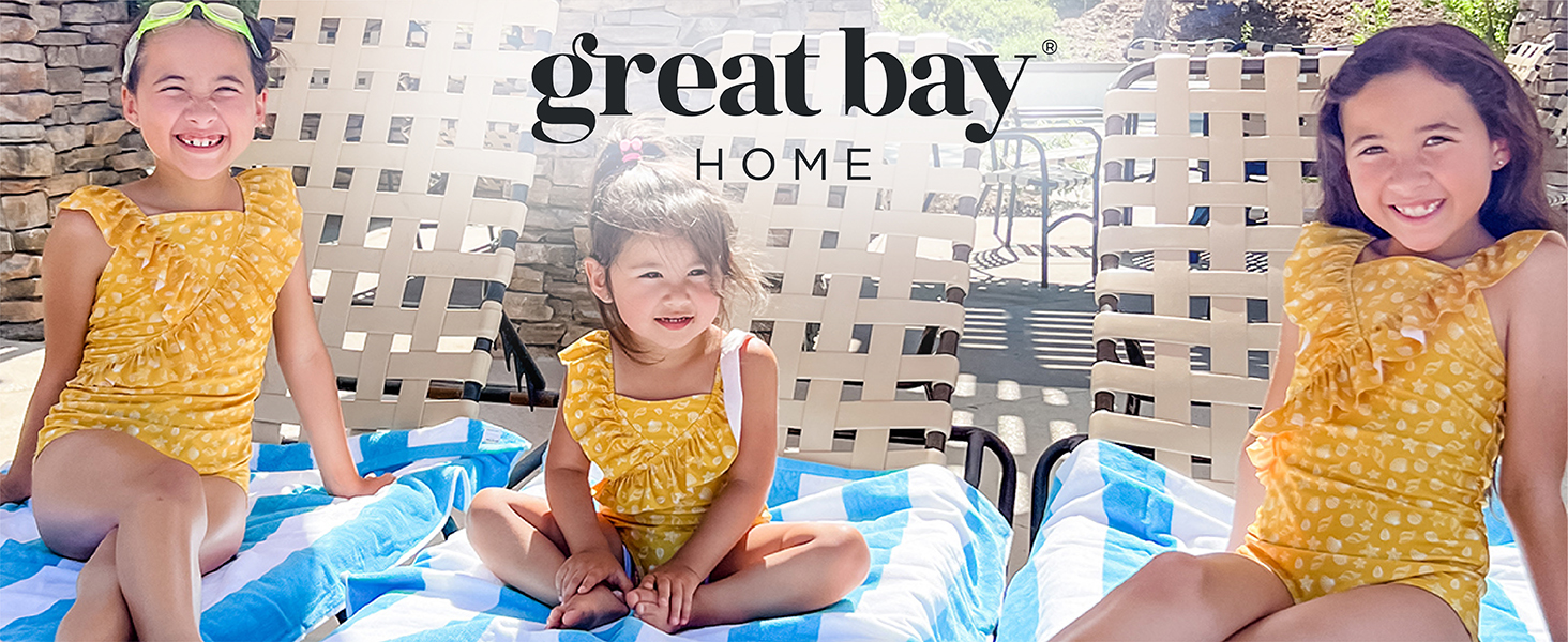 Three little girls smiling on beach chairs covered in beach towels made by Great Bay Home