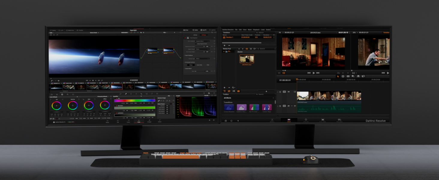 Ultrawide computer monitor displaying video editing software interface with multiple panels, timeline, color grading tools, and preview screens. Keyboard with illuminated keys visible below.