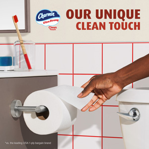 Man taking some of Charmin Ultra Strong toilet paper. Image reads "Our unique clean touch"