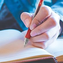 Photo shows person writing with a red G2 Fine pen