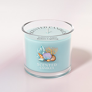 Round glass scented candle in light blue color, featuring decorative floral design on container.