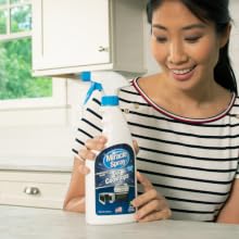 Woman holding MiracleSpray for Cooktop and Microwave