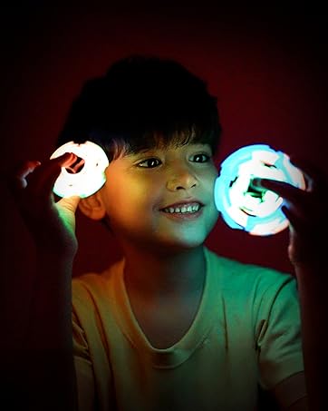 Boy playing with TOSY Fidget Spinners glowing in the dark