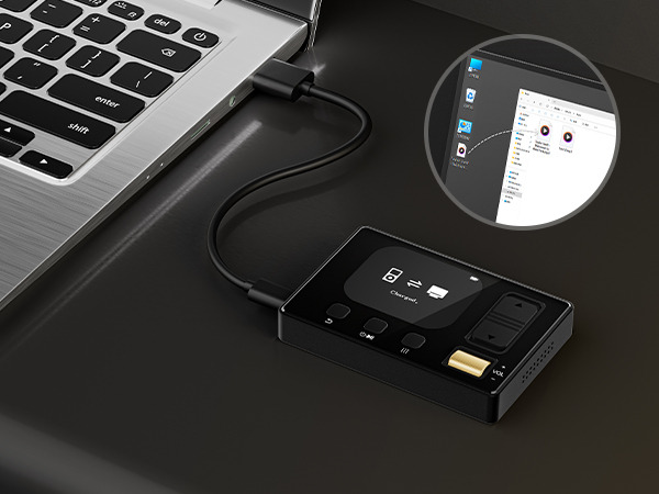 Close-up of modern technology devices including laptop keyboard, USB devices, and electronic accessories on a dark surface.