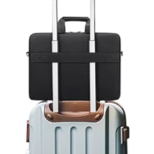 Black laptop bag with handles and strap, positioned on top of light gray hardside rolling suitcase with extendable handle.