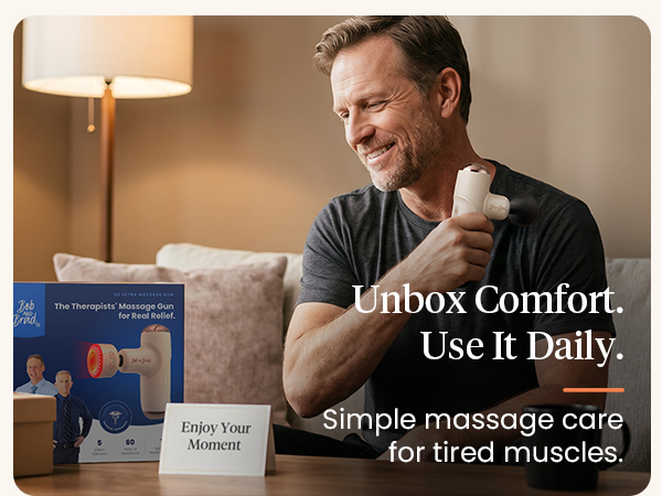 Man uses a creamy beige BOB AND BRAD mini massage gun on his shoulder beside its box.