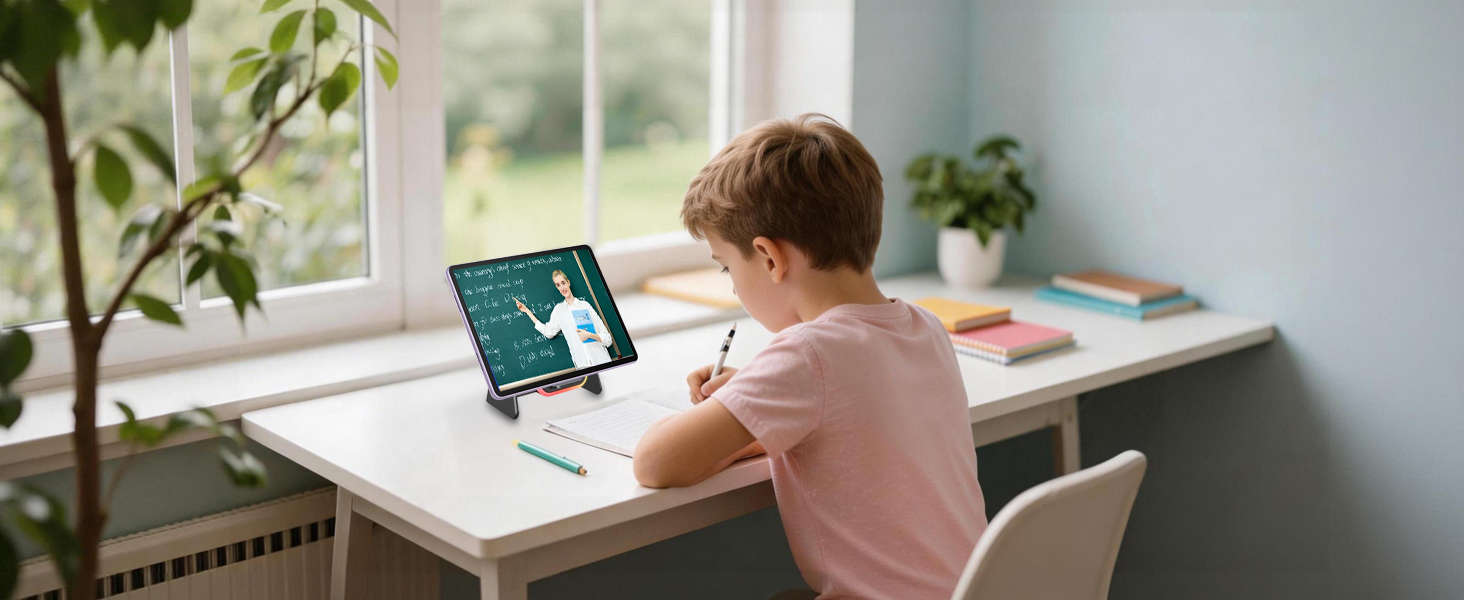 Study setup showing desk against window with laptop displaying educational content. Natural lighting illuminates the workspace with minimal decor.