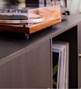 Dayton Audio turntable and bottom half of the classic bluetooth speaker sitting on a tv stand