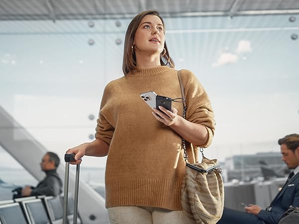 a woman in a beige sweater holding a cell phone