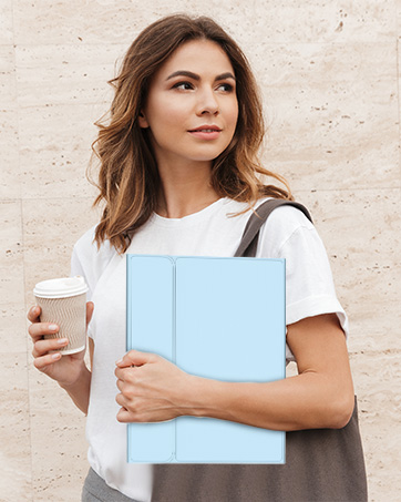 Person in white t-shirt holding various items including a disposable coffee cup and a light blue folder or notebook against a neutral beige background.