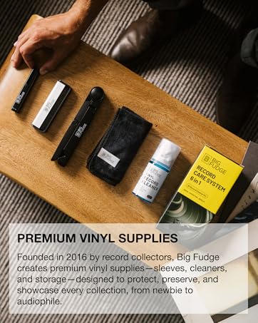 Text reads: 'PREMIUM VINYL SUPPLIES. Founded in 2016 by record collectors, Big Fudge creates high-quality vinyl supplies—sleeves, cleaners, and storage—designed to protect, preserve, and showcase every collection, from newbie to seasoned.' Display of vinyl record cleaning supplies on wooden surface.