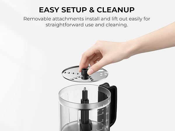 Hand holding the removable slicing and shredding disc above the 4-cup processor bowl.