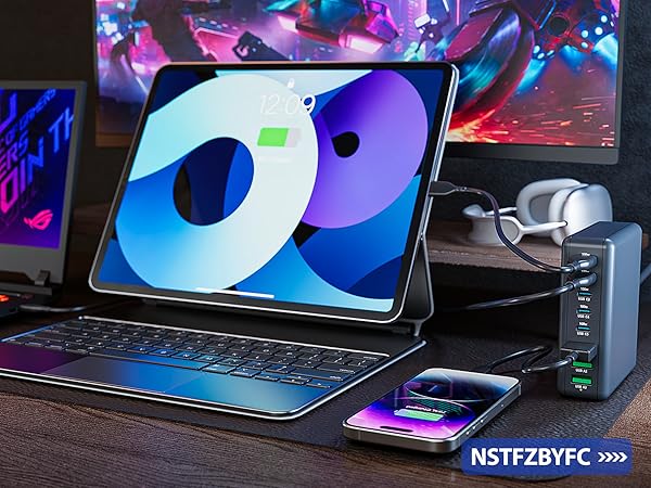 iPad or tablet computer in keyboard case setup with gaming aesthetic, wireless charging pad, and gaming peripherals on desk with RGB lighting effects.