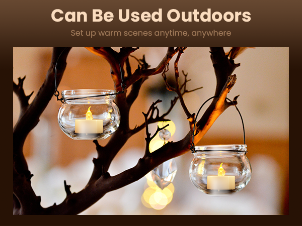 Glass jar candle holders hanging from tree branches. Lit candles inside create a warm outdoor ambiance. Text above reads 'Can Be Used Outdoors'.