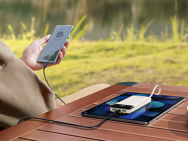 Series of images showing wireless phone charging integrated into wooden furniture surface. Phone being placed on charging area built into table.