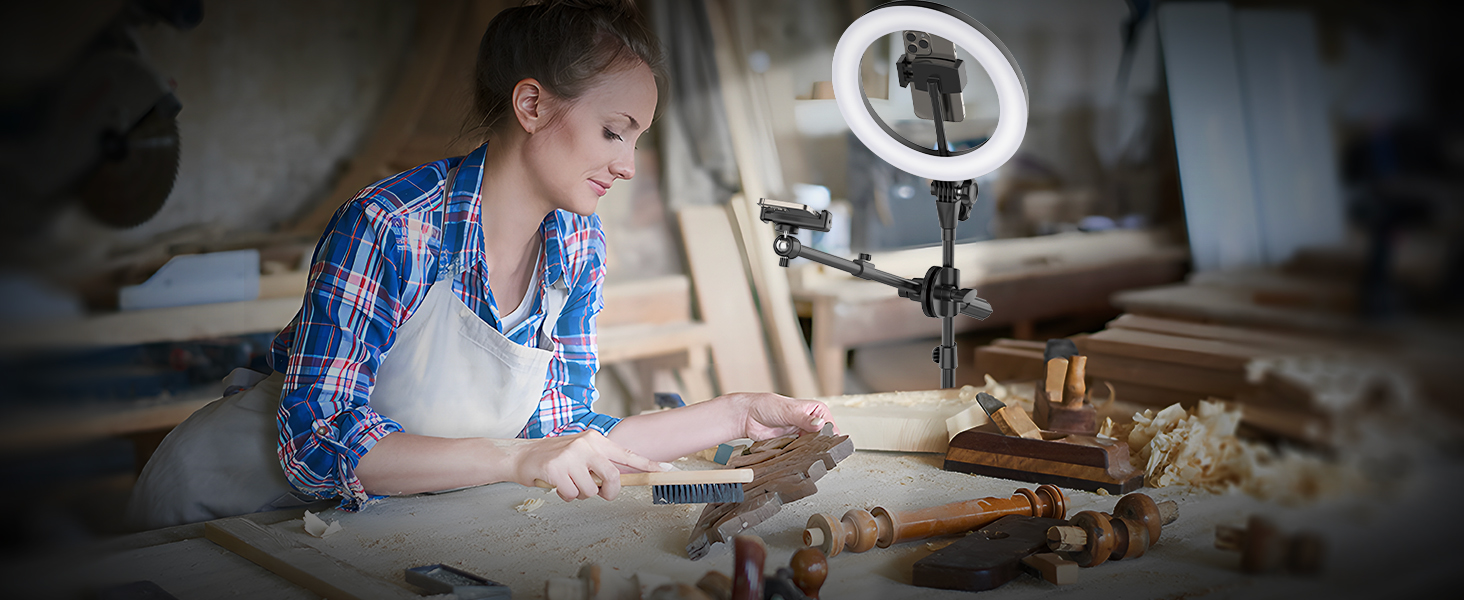 Workshop setting with LED ring light mounted on stand, illuminating a wooden workbench covered with tools and materials.