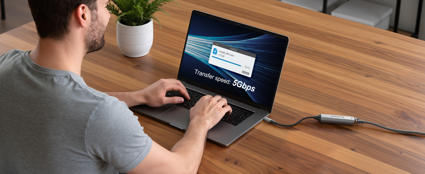 A Man Using Laptop Connected to a USB-C Ethernet Adapter for Fast 5 Gbps File Transfer