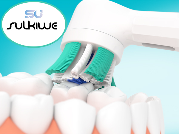 Electric toothbrush with green and white design cleaning a set of model teeth. Sukhiwe logo visible in top left corner.