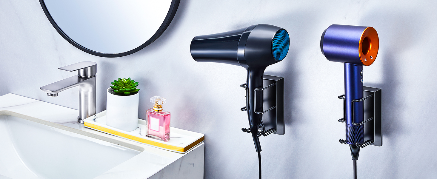Collection of household items arranged in a clean, minimalist setting including hair dryer, decorative plant, and bathroom accessories on white surfaces.