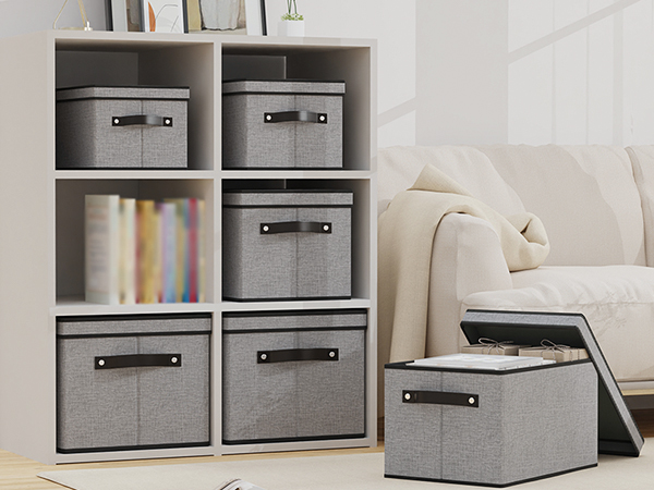 Multiple views of gray fabric storage boxes or organizers with black handles, shown both individually and stacked in various configurations.