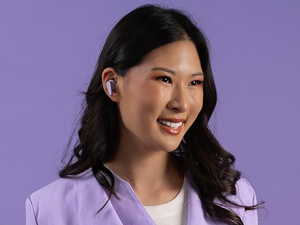 Woman wearing go pods in front of a monochrome purple background