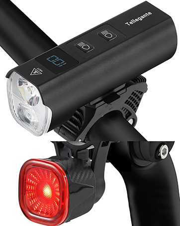 Bicycle light set with black front LED headlight and red rear light. Front light has digital display and control buttons.