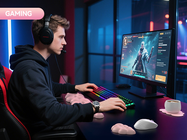 Gaming setup with RGB keyboard, large monitor displaying game interface, black headphones, and red gaming chair. Person using setup in dimly lit room with colorful ambient lighting.