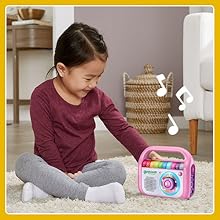 Kid smiles while listening along with music player.