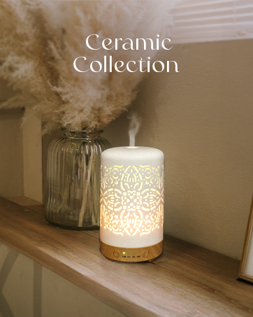 Text reads 'Ceramic Collection'. Illuminated white ceramic diffuser with intricate pattern casting light, placed on wooden shelf with decorative glass vase.