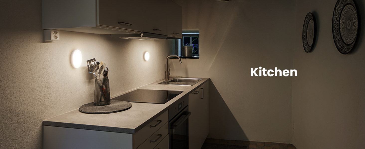 Modern kitchen corner with white countertop, built-in appliances, and wall-mounted lights. 'Kitchen' text visible in the image.