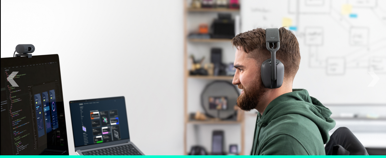 An angle image of a man wearing Zone Vibe 100 (Graphite) and working on a computer