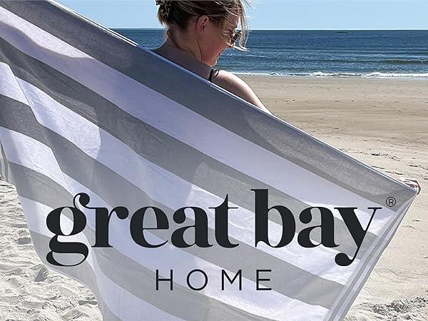 Woman holding out a cabana-striped beach towel by Great Bay Home
