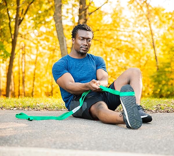 man stretching outside with a stretch out strap