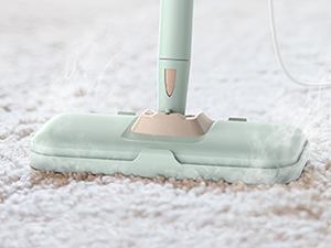 Mint green spray mop with microfiber pad gliding across a carpeted surface, featuring an ergonomic handle design.