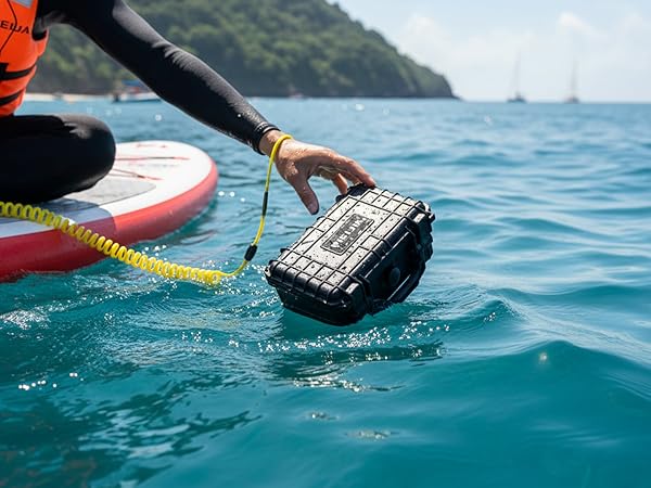 Action shot of waterproof case or container being retrieved from ocean water, with paddleboard or kayak visible in frame.
