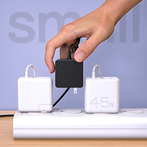 A hand plugs this Dexpt small black power adapter into a power strip beside other larger adapters.