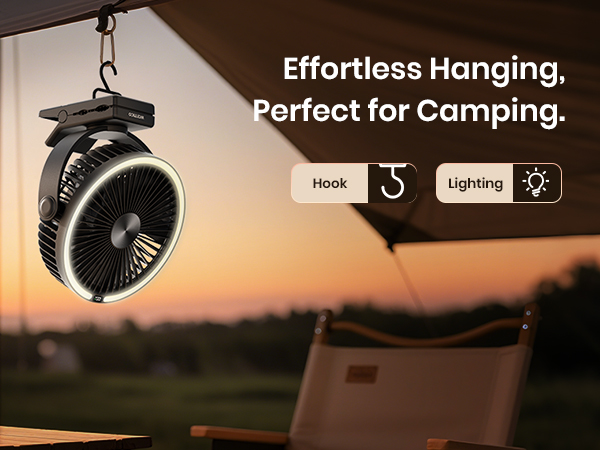 Black clip-on fan with hook and lighting, hanging from a tent at a camping site during sunset.