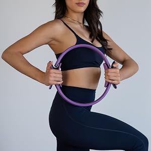 Woman holding Pilates ring, kneeling workout pose for arms, core, balance, and home Pilates training