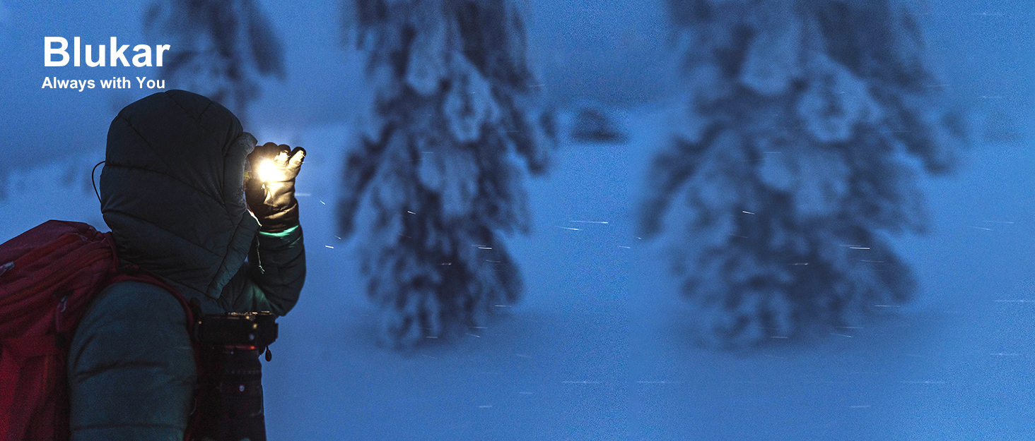 Person wearing red jacket using headlamp in snowy forest at night. Blukar logo visible.