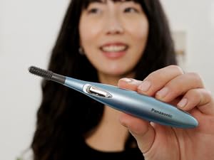 Person holding eyelash curler.