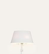 Close-up view of a white table lamp with fabric shade against a white background. Shows minimal, contemporary design aesthetic.