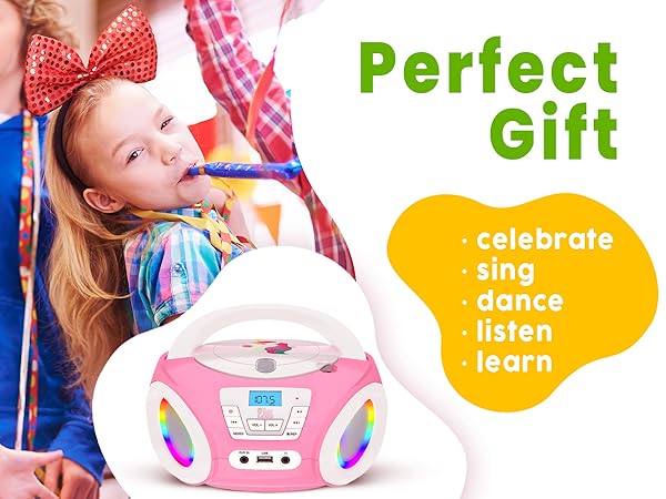 Text reads 'Perfect Gift', 'celebrate', 'sing dance', 'listen learn'. Pink children's karaoke machine with microphone, featuring colorful design elements and activity indicators.