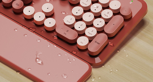 Water droplets on wireless keyboard and wrist rest showing splash resistant design easy wipe clean