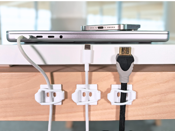 Cables secured on desk dext to laptop.
