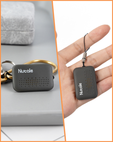 Nuvole portable device with perforated surface, shown as keychain and held in hand. Small, rectangular shape with dark gray color. Compact size emphasizes portability.