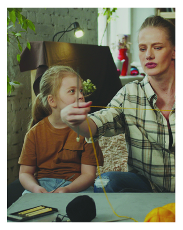 Woman teaching daughter to crochet