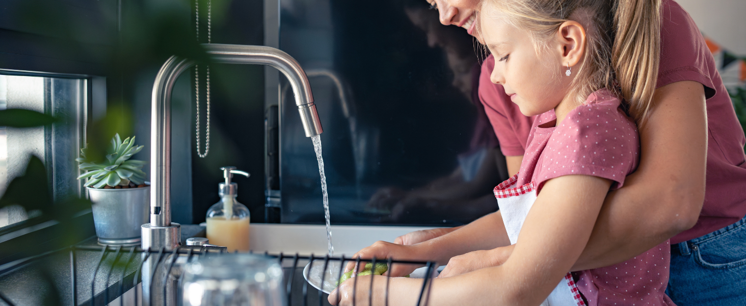 woman and child cleaning dishes together at the sink
