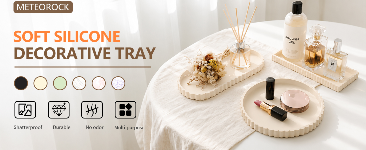 Text reads 'METEOBLOCK', 'SOFT SILICONE DECORATIVE TRAY'. Beige soft silicone tray displayed with cosmetics and jewelry. Six color circles shown: black, white, and neutral tones. Bottom icons indicate features.