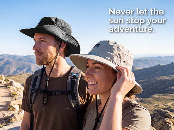 Text reads "Never let the sunstop your adventure." Two people wearing wide-brimmed hats in outdoor mountainous landscape with snow-capped peaks visible in background. Demonstrates sun protection headwear in adventure setting.
