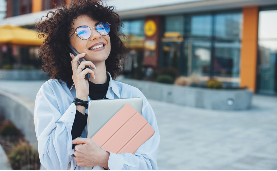 a woman with curly hair and a laptop talking on a cell phone